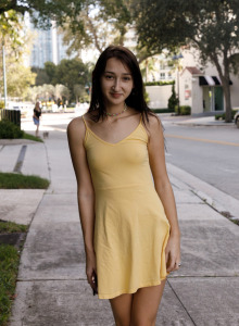 Young sexy Carmen Rae is walking across embankment in yellow see-through summer dress and flashing tits