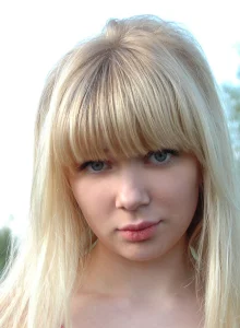 Teen blonde in sexy pink dress and denim jeans by the lake